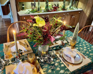 A christmas table setting with gold and green decorations.